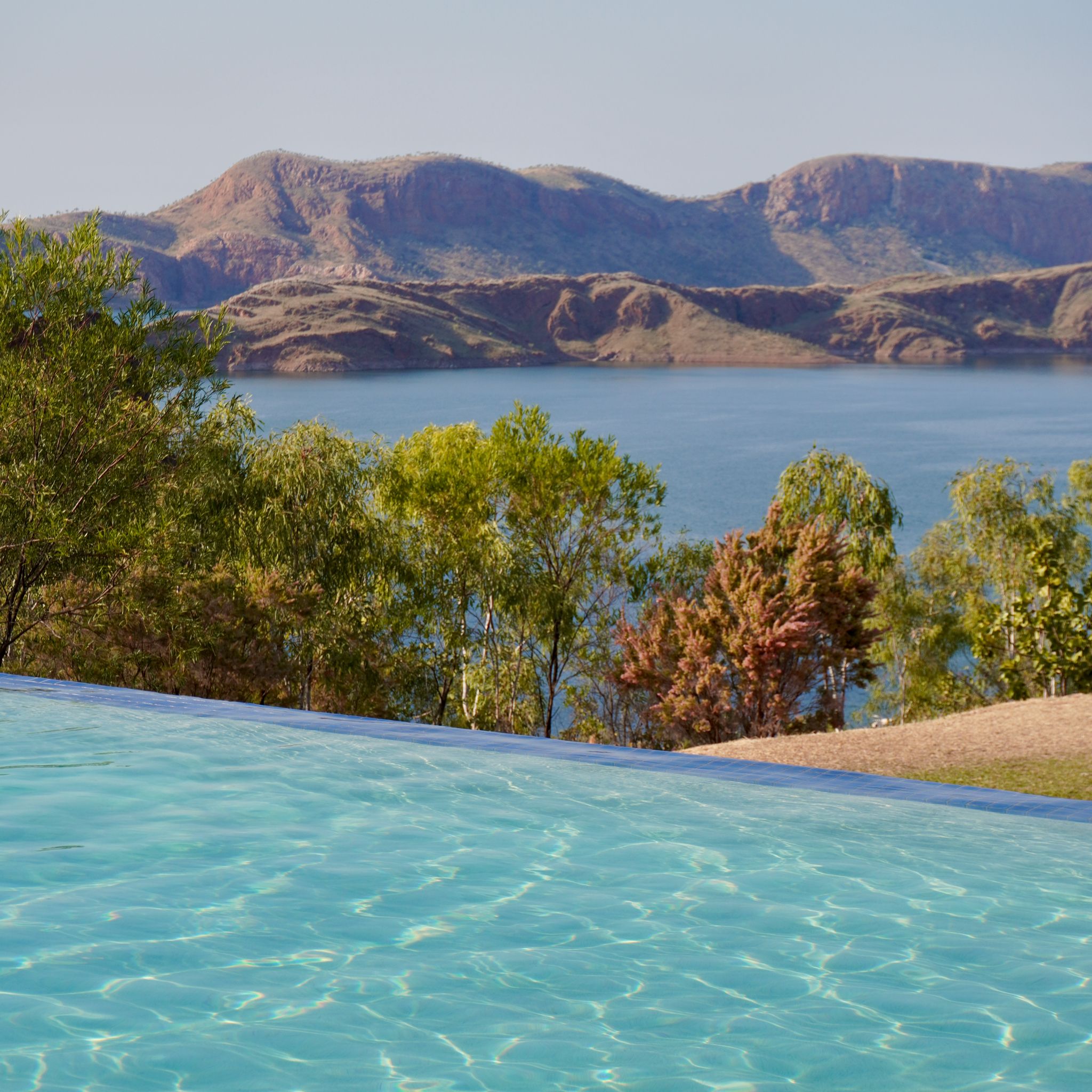 An infinity pool perched over the Lake Argyle, with the lake and the mountains in the background.