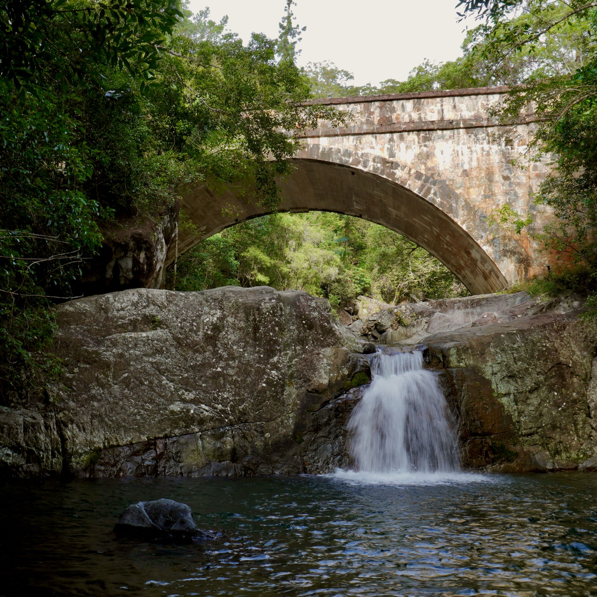 A stone arch bridge over the river at Little Crystal Creek, in Queensland.