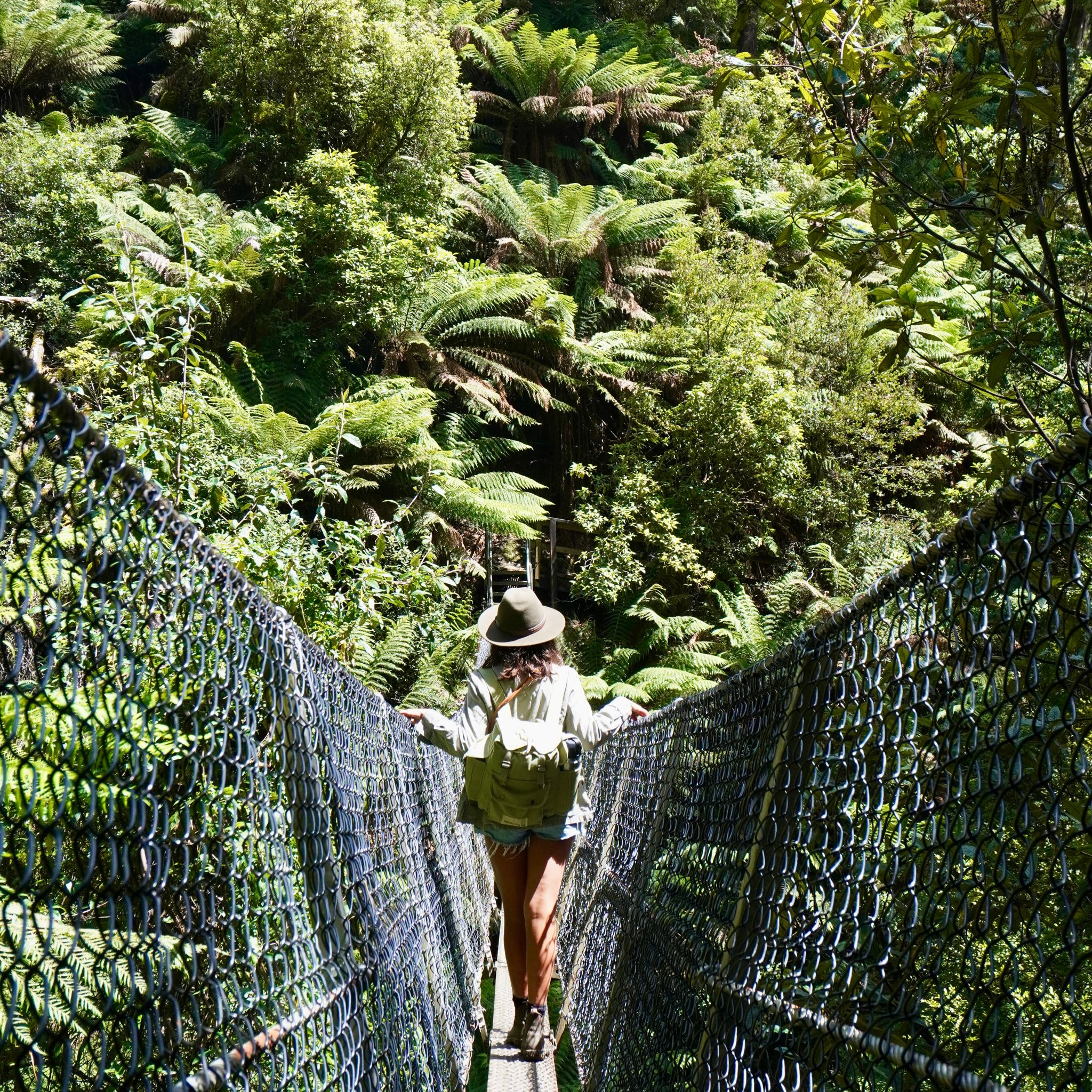 A woman crossing the suspended bridge at Montezuma Falls.