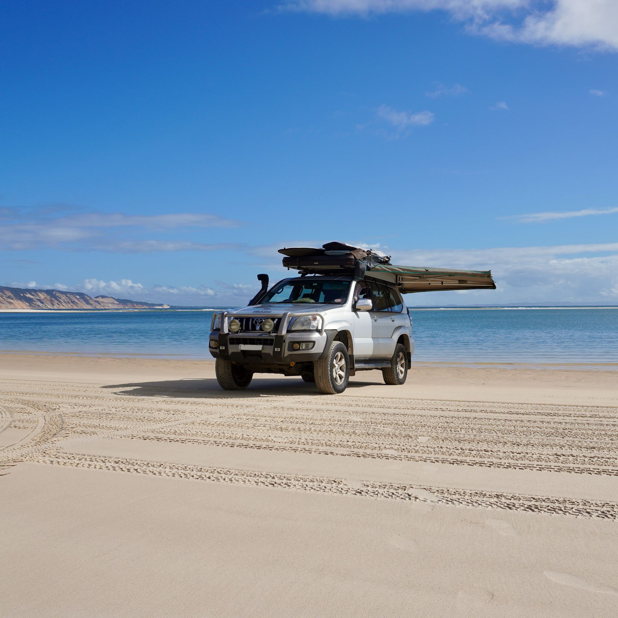 Our Toyota Landcruiser Prado, on the beach at Double Island Point with the sea and the Rainbow Beach in the background.