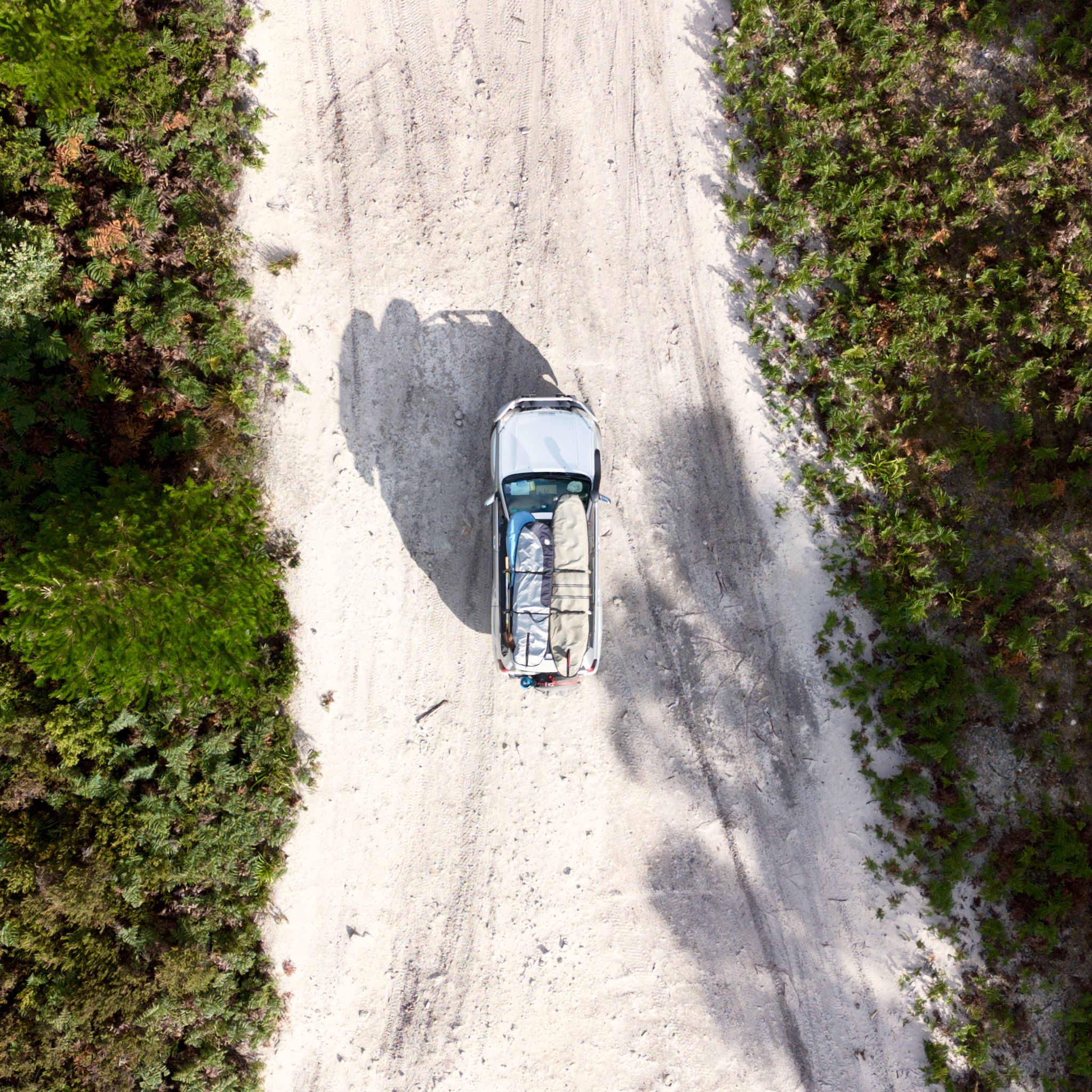 Our Toyota Landcruiser Prado photographed by a drone. It is a top-down view of the car on a dirt road.