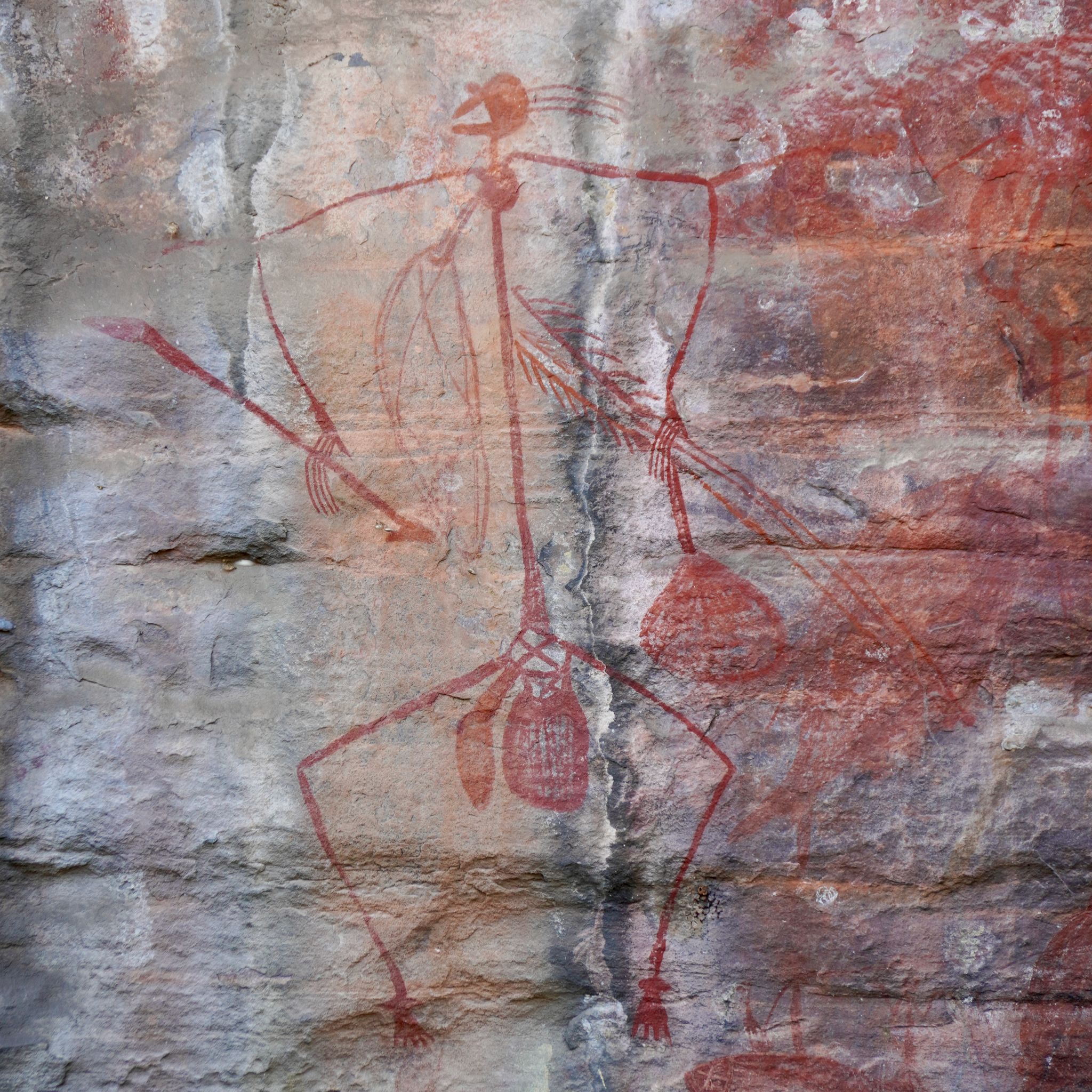 Rock paintings on the walls of a natural cave representing a a man painted in ochre.